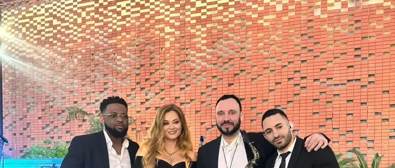 Four piece live band with a singer and a saxophonist on stage at an outdoor event in Dubai